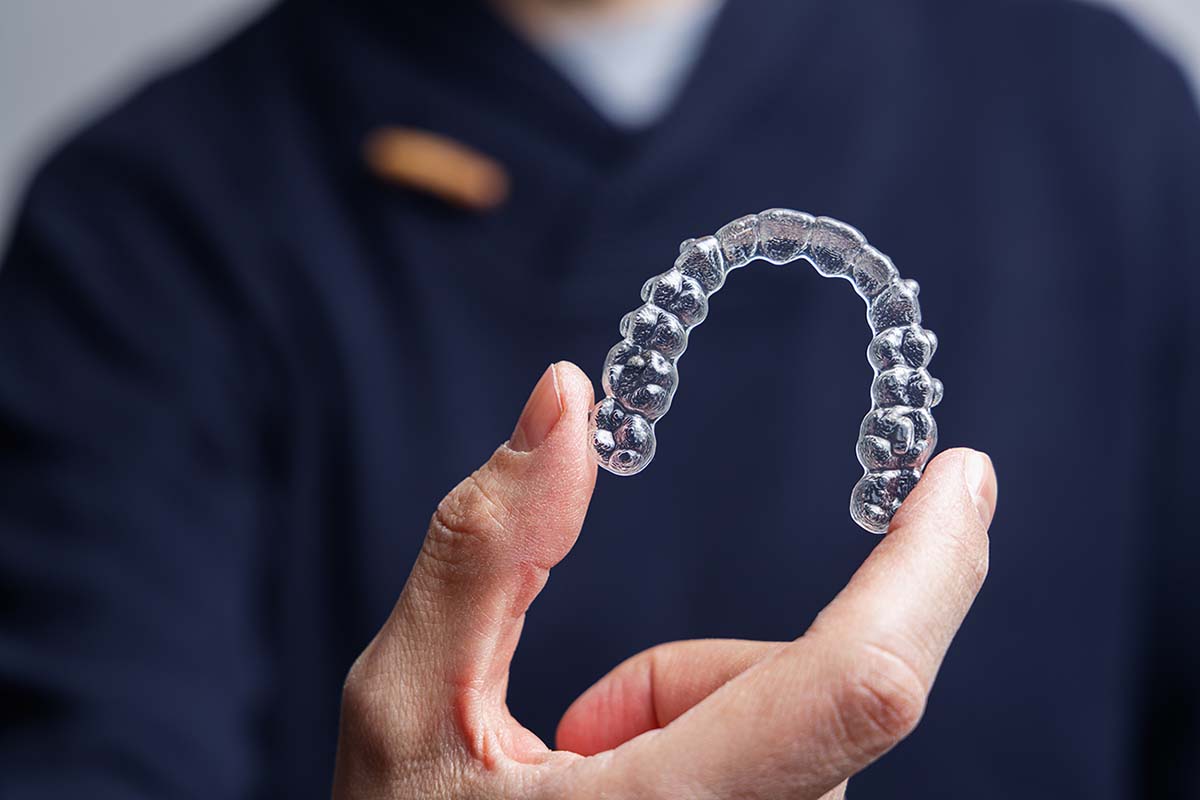 orthodontist holding a clear aligner Granite Bay Residents of Granite Bay can get a free Invisalign or braces consultation at Kelleher Orthodontics