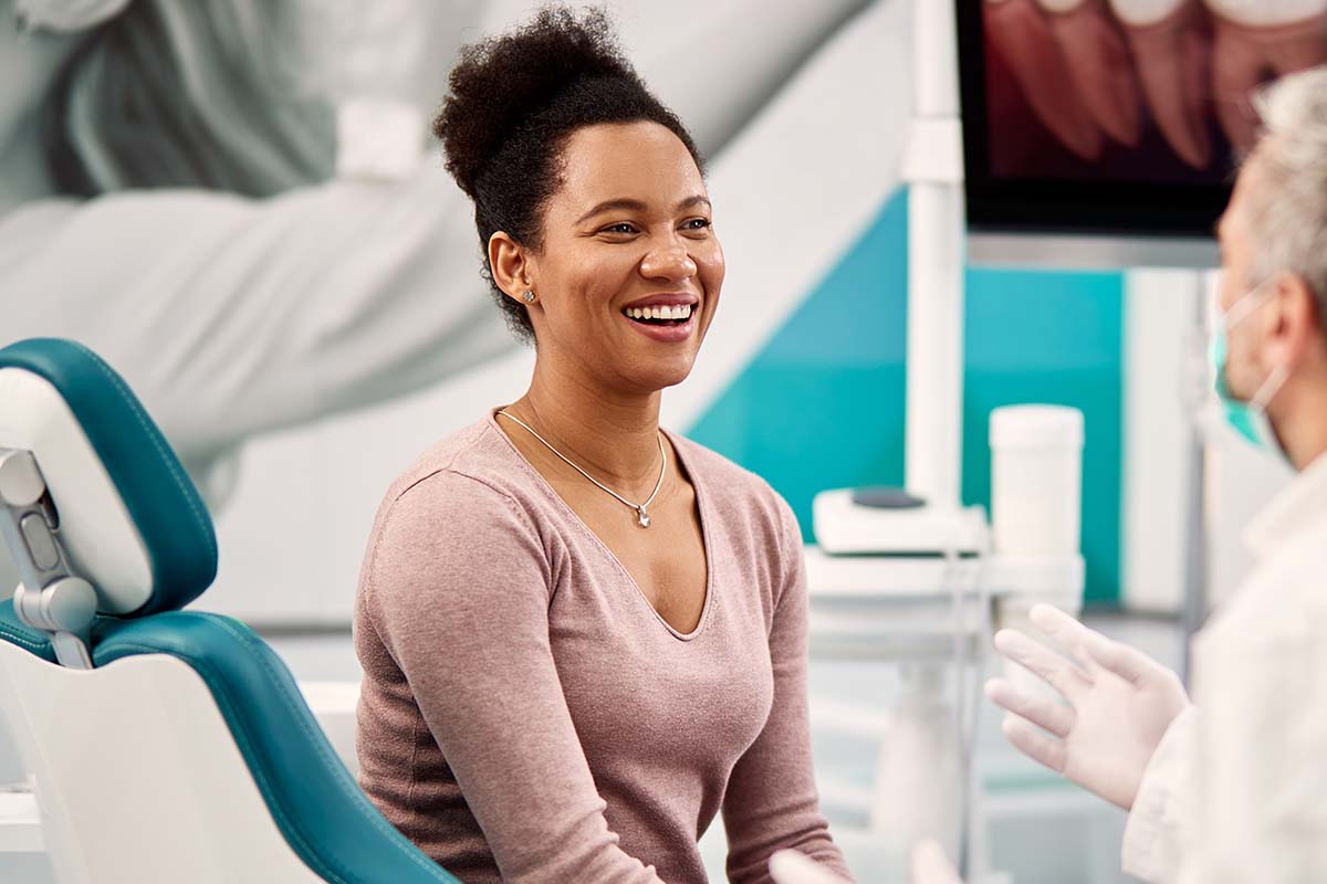 Smiling woman talks with doctor at her free orthodontic consultation Fair Oaks