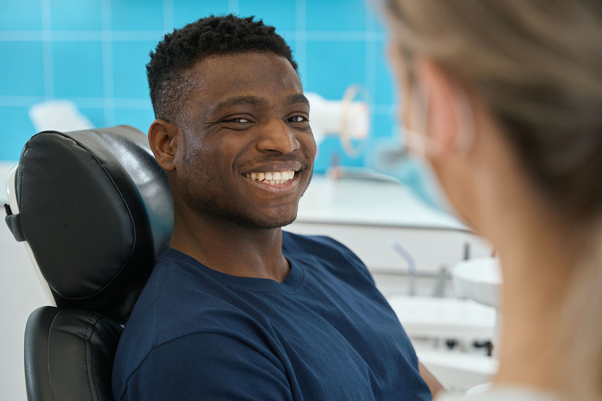Young man smiling in orthodontist chair during his free orthodontic consultation Davis